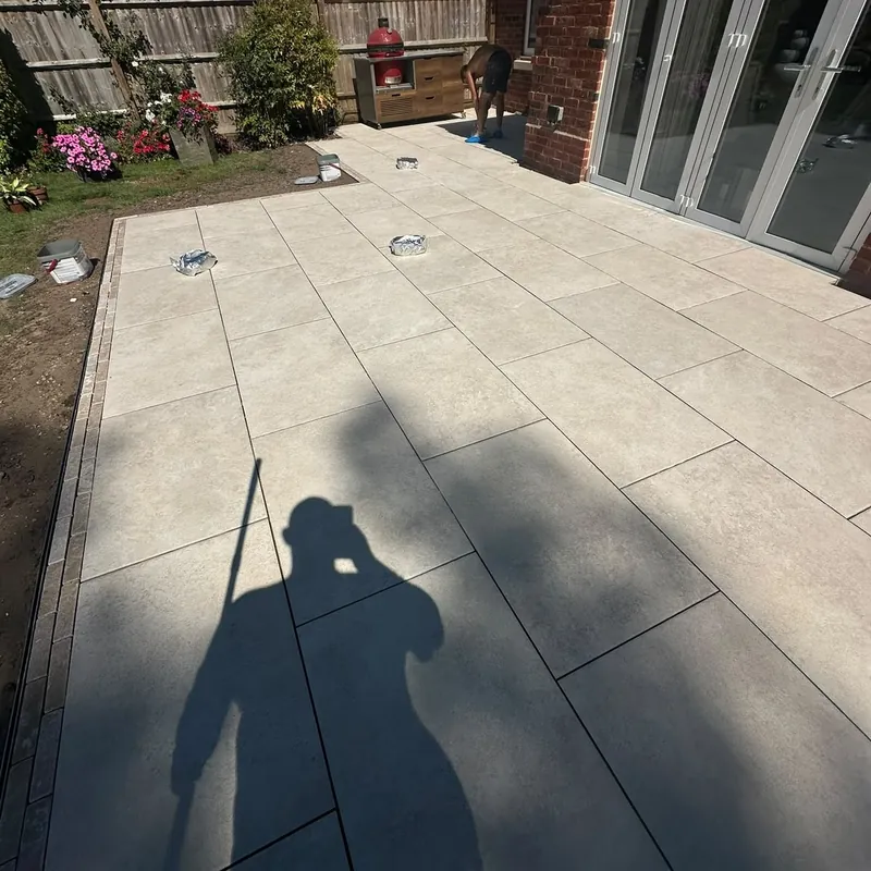 Large porcelain patio with brick edging installed by Reynolds Garden & Paving in Leicester